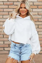 Woman in exposed seam long sleeve hoodie with denim shorts