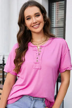 Bright pink short-sleeve henley tee with exposed seam and dropped shoulders