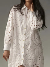 White eyelet button up longline shirt dress with intricate circular cutout patterns and gold toned buttons