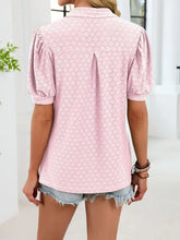 A soft pink eyelet johnny collar puff sleeve top with subtle geometric pattern and short puffed sleeves