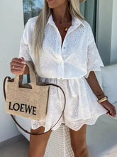 Beige gewebte Loewe Tragetasche mit schwarzem Logo und braunen Ledergriffen zu einem Lochspitzen-Overall