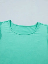 A soft mint green eyelet lace ruffled cap sleeve top with lightweight fabric and a simple round neckline