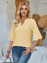 Woman in eyelet notched half sleeve V-neck top and jeans