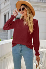 Woman in eyelet notched lantern sleeve T-shirt, jeans and wide-brimmed hat
