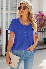 Woman in eyelet quarter button short sleeve T-shirt with jeans and clutch