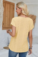 Woman in pale yellow eyelet round neck rolled short sleeve T-shirt with jeans