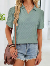 A light green eyelet short sleeve blouse with a classic collar and subtle diamond-patterned eyelet design