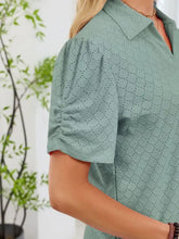 A mint green eyelet short sleeve blouse with a subtle circular pattern and ruched sleeves for stylish wear