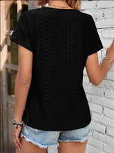 Black short-sleeve eyelet V-neck T-shirt with distressed denim shorts