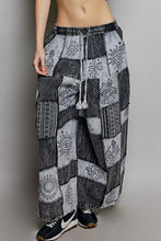 Black and gray patchwork wide leg pants with drawstring featuring embroidered eye sunburst and tribal patterns