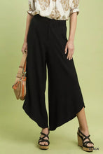 Black Umgee flowy wide leg pants featuring a high waist and a distinctive asymmetrical hem for elegant wear