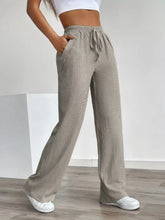 Beige textured wide leg pants with drawstring waist and side pockets showcasing texture wide leg design