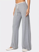Gray wide-leg lounging pants with lace trim waistband and white drawstrings featuring lace trim wide leg design