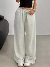 Light gray wide leg drawstring sweatpants with elastic waistband and drawstring featuring care instructions