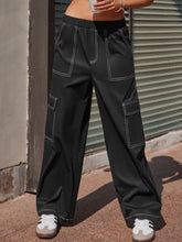 Black wide leg pants with white contrast stitching and multiple cargo pockets made from durable fabric