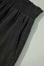 Black smocked high waist wide leg pants with gathered elastic waistband and subtle vertical seam detailing
