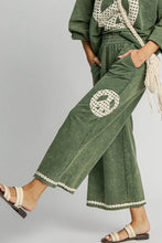 Olive green mineral wash wide leg trousers with cream lace applique peace sign patches and lace trim hem plus size