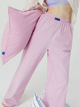 Soft pink wide leg pants with elastic waist and small blue tag designed for comfort and style