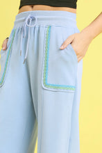 Light blue umgee drawstring wide leg pants with scallop trim detail and embroidered green and turquoise side pockets
