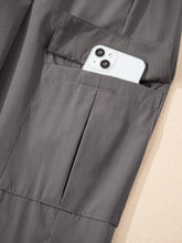 Gray elastic high waist jogger pants featuring a large functional pocket holding a white smartphone