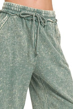 A pair of faded sage green zenana washed french terry palazzo pants with relaxed fit elastic waistband and drawstrings