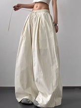 Cream-colored striped wide leg drawstring pants with subtle vertical stripes and elastic waistband for comfort