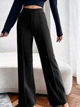 Black high waist flare pants with a tailored fit and subtle front pleats in high quality fabric