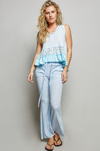 Light blue ribbed sleeveless top with ruffled hem and embroidery paired with textured ribbed breathable flare pants