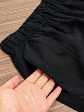 Black elastic waist pants with pockets made from soft textured fabric and a relaxed fit for comfort