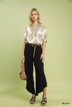 Black high-waisted umgee flowy asymmetrical hem wide leg pants with side slit for elegant casual wear