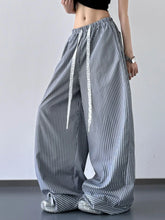 Striped wide leg drawstring pants in navy and white vertical stripes with elastic waistband and matching drawstrings