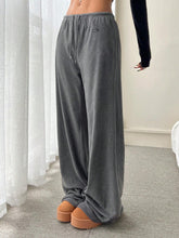 Gray velour relaxed fit drawstring pants with wide legs and a small black brand tag on the side