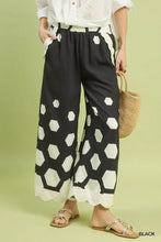 Black wide leg pants with bold white hexagon print and scalloped hem from Umgee for stylish comfort