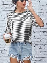 Black and white striped round neck raglan sleeve tee with distressed denim shorts
