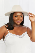 Plus-size woman in cream fedora hat, white lace camisole and black faux leather belt