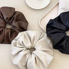 Three faux leather elastic hair scrunchies in brown, beige, black