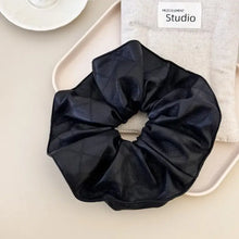 Black faux leather elastic hair scrunchy with quilted pattern