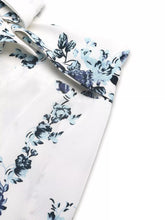 White floral print tie front wide leg pants with delicate blue and black blossoms on soft flowing fabric
