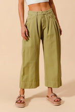 Olive green SO ME mid rise wide leg chino pants with pleated relaxed fit, rolled cuffs, and pockets, care instructions included