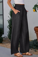 Black wide-leg trousers with smocked high waist elastic waistband and front pockets for comfortable wear