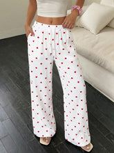 White wide-leg pants with heart print drawstring waist and ribbed texture featuring red heart pattern