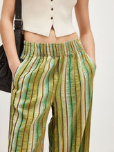 Striped high-waisted wide leg pants in olive green and cream textured fabric with subtle brown accents and care instructions