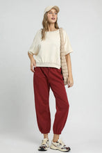 Cream-colored quilted shoulder bag with structured padded design paired with umgee fleece jogger pants with drawstring waist allows adjustable fit