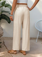Cream-colored drawstring wide leg pants with soft crinkled texture, elastic waistband, machine wash cold recommended
