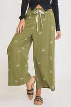 Olive green wide leg pants with white embroidered bows and lace drawstring waist from umgee plus size collection