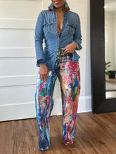 Blue denim shirt with buttoned front and chest pockets paired with painted wide leg pants for a stylish look
