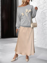 A beige satin midi skirt with smooth flowing drape pairs elegantly with a floral applique boat neck sweatshirt slightly stretchy and machine wash cold
