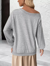A soft heather gray floral applique boat neck sweatshirt with relaxed fit ribbed cuffs and slightly stretchy fabric machine wash cold