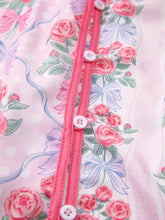 Pink floral-patterned ruffled half sleeve shirt with satin-like fabric and matching pink button closure