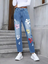 Floral embroidered high waist distressed blue denim jeans with colorful pink white yellow and red flowers